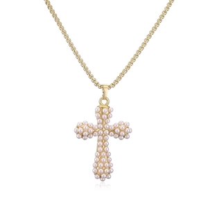 Detailed close-up of golden cross pendant with small inlaid pearls on a box chain necklace