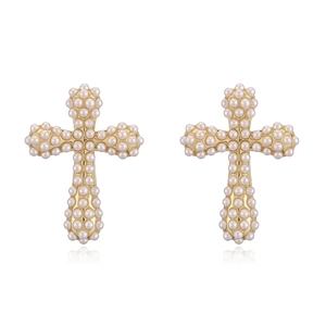 Close-up of golden cross earrings with white imitation pearls on a white background