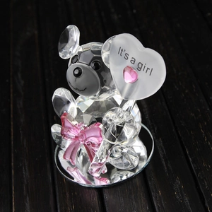 Crystal bear figurine with pink bow and heart sign on a reflective base for baby shower