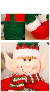 Close-up of Christmas elf doll featuring red and green plush fabric with candy buttons