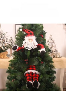 Close-up of Santa Claus plush doll with red and black plaid fabric on a Christmas tree