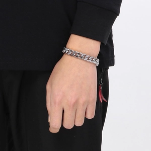 Sleek silver Cuban link bracelet for men shown on wrist against a dark background