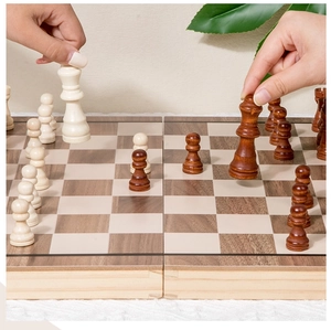 Close-up of hands moving wooden chess pieces on a foldable magnetic chessboard