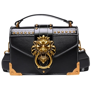 Retro black lychee leather handbag with golden lion head clasp and studs on white background