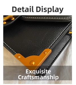 Close-up of black lychee texture leather bag with gold metal corners and white stitching