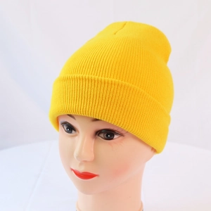 Detail of bright yellow knitted beanie showing fine ribbed texture on a model head
