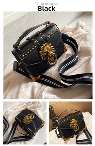 Detail of black vintage PU bag with golden lion head buckle and studded metal corners