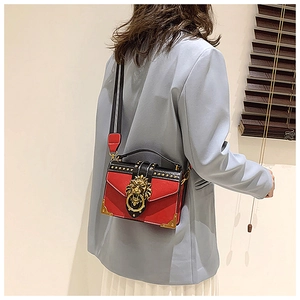 Close-up of retro rivet handbag with lion head buckle and striped strap on model