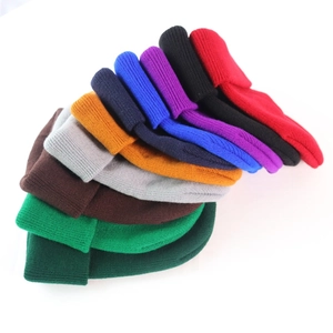 Detailed view of stacked knitted beanies in multiple vibrant colors for winter warmth
