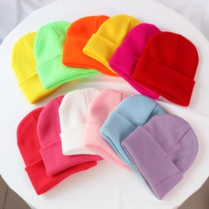 Colorful knitted beanies arranged in a circle on a white base showcasing all color options