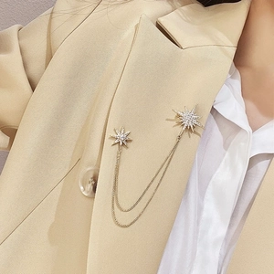 Elegant gold double chain star brooch with sparkling zircon on a beige blazer jacket