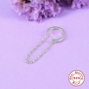 Detail of silver S925 chain fringe ear cuff on a lavender textured background with dried flowers