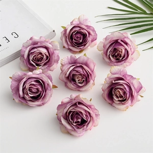 Close-up of eight purple gradient silk rose heads with green leaves on a magazine