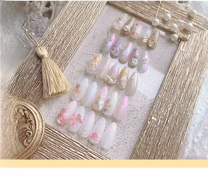 Detailansicht von 3D-Blumen-Kunstnägeln mit Perlen und Goldfolie im Vintage-Rahmen