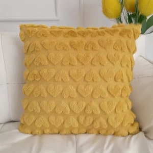 Yellow plush heart-textured square pillow cover on a white sofa with warm home decor
