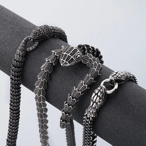 Detailed view of three vintage snake-shaped steel necklaces with textured scales