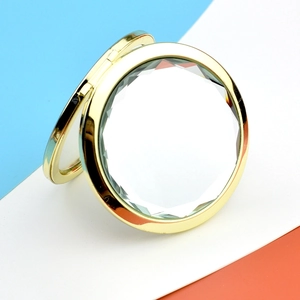 Elegant round gold metal folding makeup mirror with crystal surface on tri-color background