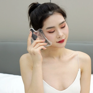 3D heart-shaped facial massage tool made of clear resin used by a female model