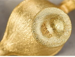Macro detail of S925 hallmark on gold plated sterling silver Aladdin lamp necklace