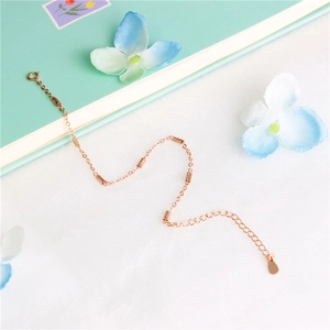 Elegant rose gold bracelet with geometric cylindrical beads on soft white fabric