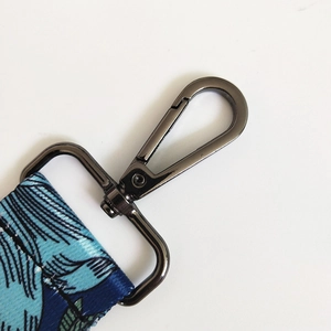 Detail of gunmetal swivel hook and blue floral printed strap for shoulder bags