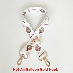 Close-up of hot air balloon print bag strap with golden metal hooks and Journey text