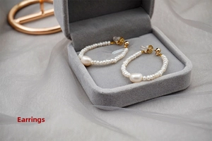 Detail of freshwater pearl hoop earrings with baroque drop in a velvet jewelry box