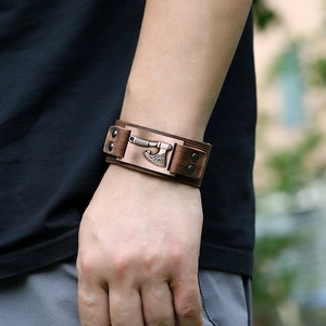 Vintage Viking leather bracelet with brown metallic axe charm on a male wrist