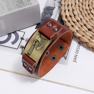 Detail of vintage brown leather bracelet with bronze viking axe charm and snap buttons
