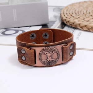 Macro view of vintage Viking Tree of Life bronze emblem on brown leather bracelet