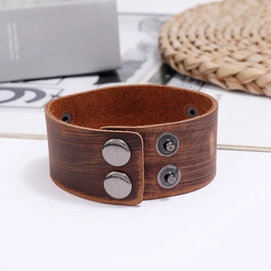 Detail of vintage brown leather wide bracelet with textured finish and four metal snaps