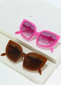 Detail of cat eye sunglasses with metal rivets on rose and amber frames