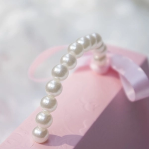 Pink gift box with elegant white pearl handle and decorative pink ribbon bow for wedding