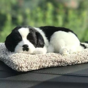 Macro shot of realistic black and white sleeping plush dog on a soft beige mat