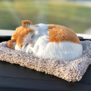 Detailed view of a realistic orange and white plush sleeping cat on a cozy beige mat