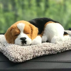 Realistic sleeping tricolor beagle plush toy on a soft beige mat with a natural background