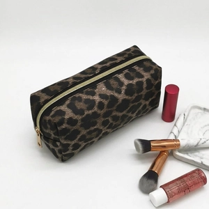 Leopard print makeup bag with gold zipper and accessories on a clean white background