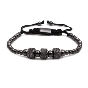 Gros plan d'un bracelet de perles noir fusil avec cylindres en zircon et cordon réglable