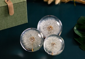 Detailed view of three resin dandelion crystal balls on a dark table decoration