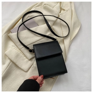Close-up of black rectangular crossbody phone bag on cream blazer for work style