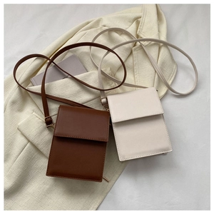 Flat lay of brown and beige minimalist crossbody bags on a chic blazer background