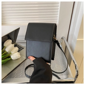 Close-up of minimalist black square crossbody phone bag with polished PU leather finish