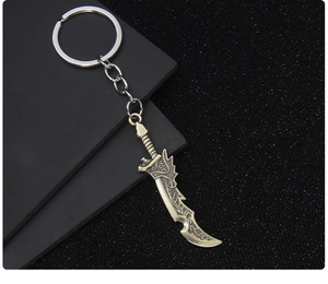 Close-up of bronze-finish metal sword keychain with intricate textures on dark background