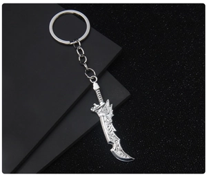 Detail of silver metal sword keychain pendant on a professional black textured surface