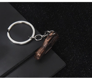 Macro view of a retro bronze car pendant keychain with a silver chain and ring