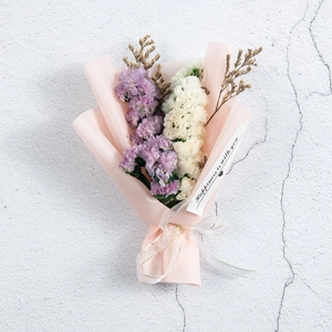 Detail of purple and white dried baby's breath bouquet with a happiness message tag