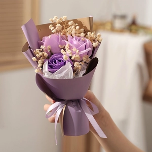 Detail of mini soap flower bouquet with purple roses and gypsophila in gift wrap