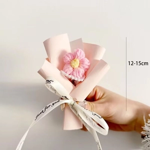 Close-up of a handmade pink crochet flower bouquet measuring 12-15cm with white ribbon