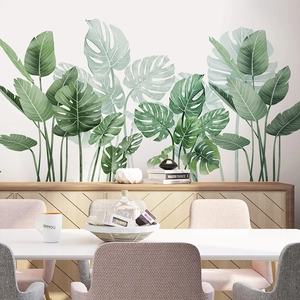 Large tropical monstera and banana leaf wall stickers in a modern minimalist dining room