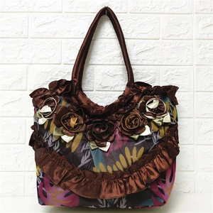 Close-up of large brown satin tote bag with handcrafted 3D fabric flower and leaf print